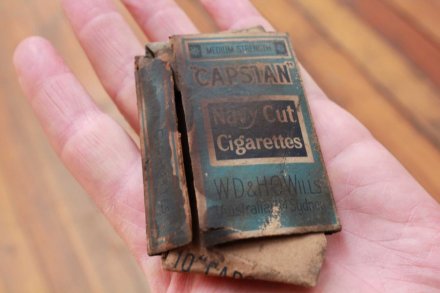 Bungkus rokok berusia lebih dari satu abad ini ditemukan disela-sela papan kayu pelapis lantai di sebuah gedung yang tengah direnovasi di Hobart, Tasmania. (Credit: ABC) 