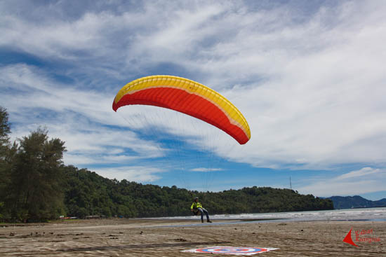 Susana Yassin, atlet paralayang senior kota Padang, mendarat mulus di Pantai Air Manis. FOTO : FRINO BARIARCIANUR