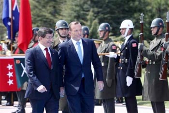 Ahmet Davatoglu dan Tony Abbott memeriksa barisan kehormatan di Istana Cankaya Palace di Ankara FOTO : AFP 