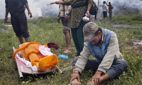 Duka yang mendalam menggelayuti langit Nepal usai diguncang gempa tektonik 7,9 SR. Sehari kemudian, ribuan orang dikremasi di Kuil Pashupatinath, Sungai Bagmati, Kathmandu, Nepal, 26 April 2015. FOTO : AP PHOTO/BERNAT ARMANGUE