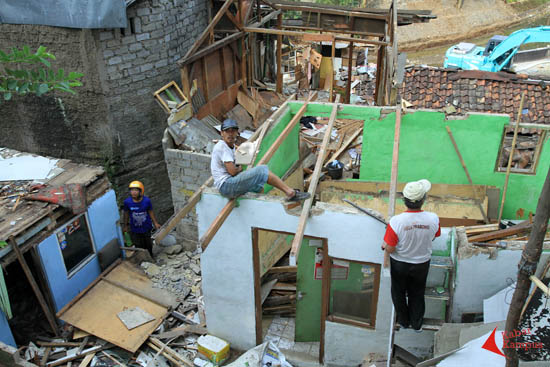 Warga "Kampung Kolase" yang digusur mengambil bahan bangunan 