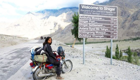 Zenith berfoto di depan penanda jalan setelah menjangkau Lembah Shigar di perjalanannya dari Lahore ke Khunjerab.  Facebook; Zenith Irfan