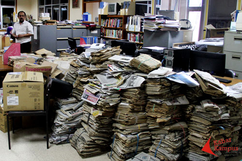 Agung Trianggono diantara tumpukan koran tua. FOTO ; FRINO BARIARCIANUR