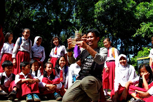 Adi Firmansyah dari komunitas Earth Hour Bandung mengajarkan sistem tanaman hidroponik kepada anak-anak SD pada peringatan Hari Bumi di kawasan hutan Babakan Siliwangi, Bandung, Selasa (22/04/2014). FOTO : FRINO BARIARCIANUR 