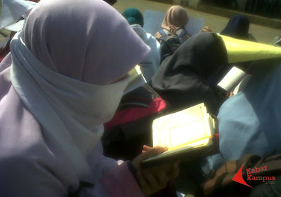 Mahasiswi yang tergabung dalam Aliansi Universitas Islam Negeri Sunan Gunung Djati Bandung Tanpa JIL membaca Alquran disela-sela aksi demonstrasi di depan kampus UIN SGD Bandung, Senin (05/05/2014). FOTO : FRINO BARIARCIANUR