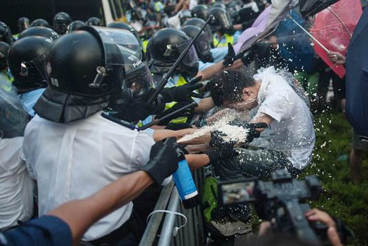 Pihak kepolisian Hongkong menyemprotkan busa merica ke arah aktivis pro demokrasi Hongkong. FOTO : GETYY IMAGES