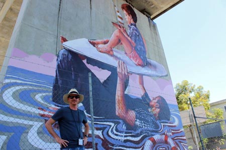 Manager Proyek, Dan Brock berdiri di depan mural karya seniman Fintan McGee.