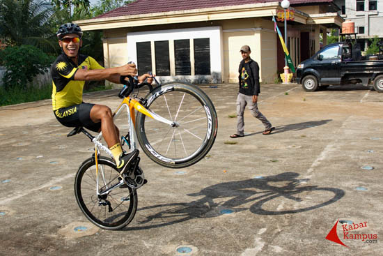 Atlet balap sepeda asal Malaysia melakukan aksi menyapa warga.