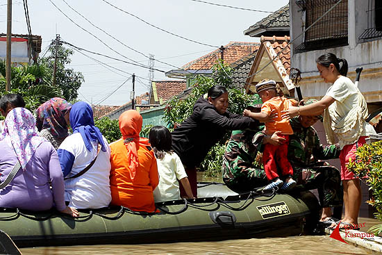 Tim relawan dari Yon Zipur 3 membantu warga korban banjir di kawasan Dayeuhkolot, Kabupaten Bandung, Kamis (25/12/2014). Pemerintah telah mengeluarkan dana miliaran rumah untuk normalisasi Sungai Citarum namun banjir masih terus menerjang Bandung selatan. FOTO : FRINO BARIARCIANUR