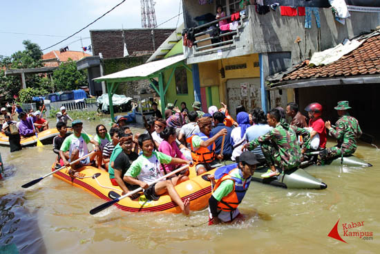 Warga terus melakukan aktivitas untuk mempertahankan hidup meski bencana banjir telah memasuki hari ke-6, Dayeuhkolot, Kabupaten Bandung (25/12/2014). Untuk mendapatkan air bersih dan juga makanan tim relawan yang juga korban banjir selalu siap membantu warga. FOTO : FRINO BARIARCIANUR