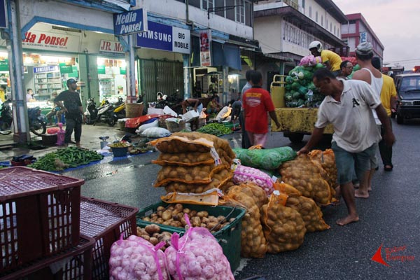 Para pedagang Pasar Beringin yang terkena banjir menyiapkan lapak di kawasan Tugu Naga, Singkawang, Jumat (23/01/2015). Hujan yang mengguyur sejak pukul 13.00 WIB menyebabkan Sungai Singkawang meluap menggenangi kota Singkawang. Pada hari Rabu sore banjir bandang menghantam kawasan Pajintan - Sanggau Kulor yang terletak di Singkawang Timur. FOTO : FRINO BARIARCIANUR