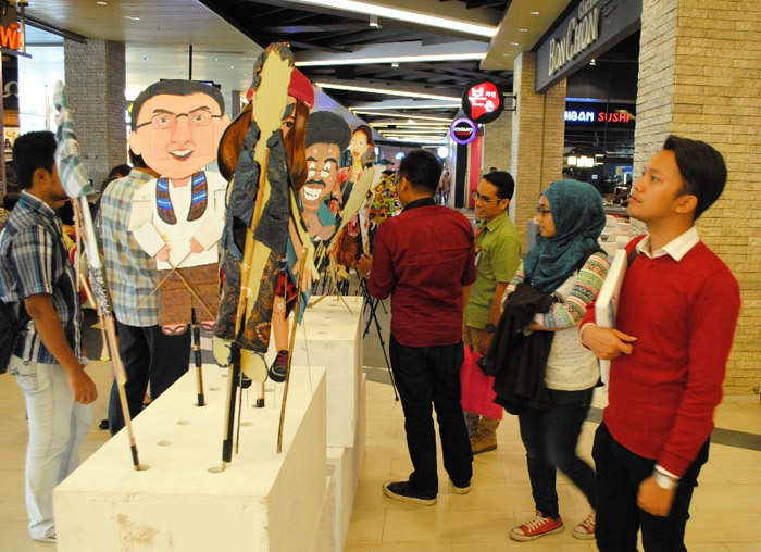Pengunjung sedang melihat wayang tokoh Jakarta  di pameran Greeneration Binus University.