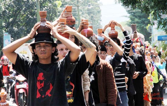 Lebih dari 200 warga Bandung yang tergabung dalam Bandung People Forum melakukan arak-arakan untuk memperingati Hari Bumi dari Babakan Siliwangi menuju kantor PDAM Bandung di jalan Badak Singa, Bandung, Rabu, (22/04/2015). Dalam aksi ini mereka menyuaraka perlawanan rakyat Asia Afrika terhadap privatisasi air. FOTO : Fauzan Sazli