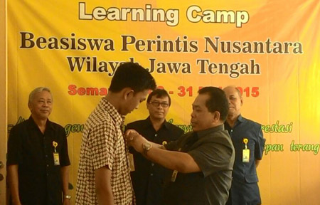  Rektor Unnes menyematkan tanda pengenal kepada peserta learning camp. Foto : Unnes