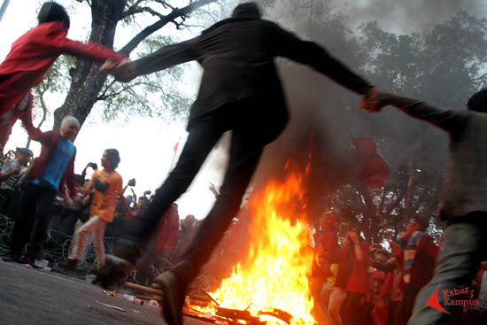 Aksi massa Aliansi Tarik Mandat mengelilingi api sambil meriakan yel-yel perjuangan saat berdemonstrasi mengkritisi pemerintahan Jokowi-JK di depan Istana Negara, Jakarta, Kamis (21/05/2015). FOTO : FRINO BARIARCIANUR