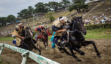 Para samurai bertarung dalam perlombaan balapan kuda bersenjata (Kacchu-keiba) dalam acara Festival Soma Nomaoi yang dilangsungkan di Hibarigahara. Minamisoma, Jepang (25/07/2015). FOTO : CHRIS McGRATH/Getty Images