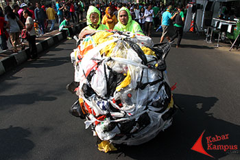 Dua seniman "Invalid Urban" membawa buntelan sampah di acara Car Free Daya, jalan Dago, Bandung, Minggu, (23/09/2015). Foto : Fauzan Sazli