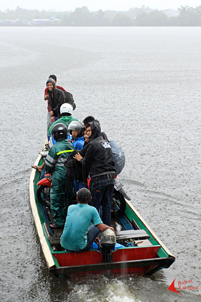 Warga tetap menyeberang meski hujan mengguyur di Sungai Sekura, Sambas, Kamis (03/09/2015).