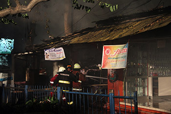 Petugas pemadam kebakaran memadamkan kios yang mulai terbakar di depan kampus Unpas Bandun, Minggu, malam, (04/10/2015). Foto : Fauzan Sazli.