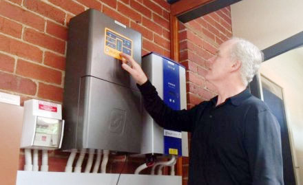 Michael McGarvie sedang menginstal sistem baterai panel surya di rumahnya di Melbourne. FOTO : ABC