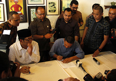 Taufik Hidayat dan Ridwan Kamil menandatangani kesepakatan damai di Bandung, Selasa, (19/04/2016). Foto : Fauzan
